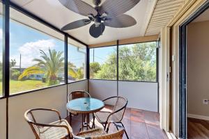 a screened porch with a table and chairs and a ceiling fan at SEA STAR in Cape Canaveral