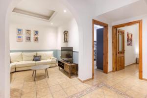 a living room with a couch and a tv at Ta' Lorita - Charming & Cosy Ground Floor Family Home in Birgu