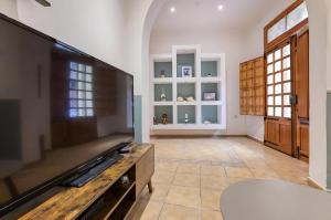 a large living room with a flat screen tv at Ta' Lorita - Charming & Cosy Ground Floor Family Home in Birgu