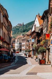 eine Stadtstraße mit Gebäuden und einem Berg im Hintergrund in der Unterkunft Albert Ranch House - Grande maison au calme - Parking in Ribeauvillé