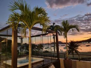 a view of the beach from a resort with palm trees at Sintonia com o Mar in Angra dos Reis