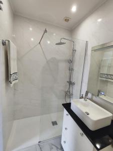 a white bathroom with a sink and a shower at Casa Maria in Loures +10 photos