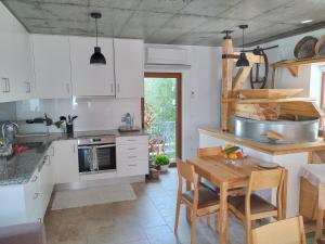 eine Küche mit weißen Schränken und einem Holztisch in der Unterkunft Moinho Real in Redinha