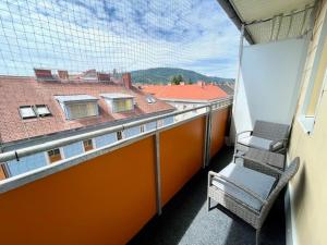 a balcony with a chair and a view of a building at Zentrales City Apartment in Graz