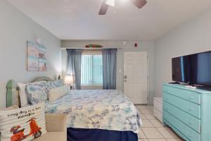 een slaapkamer met een bed en een flatscreen-tv bij Pass-A-Grille Beach Retreat Unit 8 in St Pete Beach