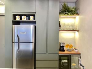eine Küche mit einem Kühlschrank aus Edelstahl und Regalen in der Unterkunft Luxury Collection Cama Queen e Sofá Cama Separado in Campo Grande
