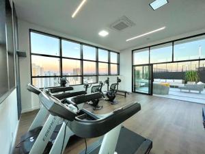 ein Fitnessstudio mit Cardiogeräten in einem Raum mit großen Fenstern in der Unterkunft Luxury Collection Cama Queen e Sofá Cama Separado in Campo Grande
