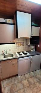 a kitchen with a stove and a sink at Résidence Makalu - Studio divisible 4 personnes Plagne Centre MAE-3484 in Aime La Plagne +8 photos