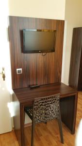 a wooden desk with a television on a wall at Hotel Abendstern in Berlin