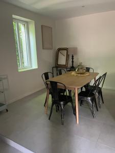 a dining room table with black chairs and a mirror at Maison au bord de la Loire in Saint-Jean-le-Blanc +3 photos
