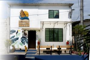 a white house with two benches in front of it at Hotel Estación del Sol in Las Núñez