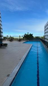 Una piscina con agua azul frente a un edificio. en Recife Pina Boa Viagem Beach, en Recife 9 fotos más