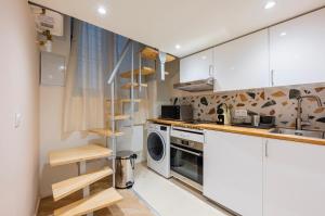 a kitchen with white cabinets and a washer and dryer at Hyper centre Écusson - Magnifique T1 au calme in Montpellier