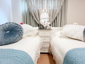 - une chambre avec deux lits et une commode avec une lampe dans l'établissement Asagoya Okinawa Resort - Vacation STAY 67103v, à Urasaki