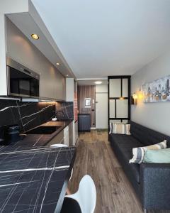 a living room with a couch and a tv at Bel appartement neuf, proche Paris et Orly in Savigny-sur-Orge