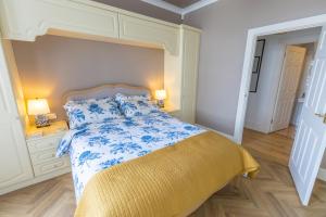 a bedroom with a bed with a blue and white bedspread at Port Lush in Portrush