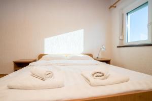 a bedroom with a bed with towels on it at Sunset Holiday3 in Njivice