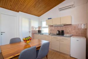 a kitchen with a wooden table with a bowl of fruit on it at Sunset Holiday3 in Njivice