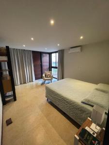 a bedroom with a bed and a chair in it at Casa Dois Mares in Pipa