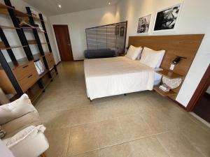 a large bedroom with a bed and a couch at Casa Dois Mares in Pipa