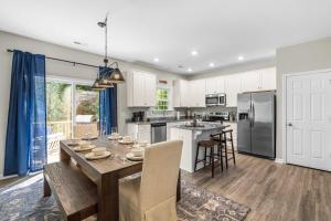a kitchen and dining room with a table and chairs at Charming 5bd - BBQ - Deck- 4mins Duke University in Durham