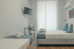 a bedroom with two beds and a tv on the wall at CH Barco in Madrid