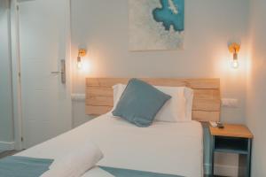 a bedroom with a bed with a blue pillow on it at CH Barco in Madrid