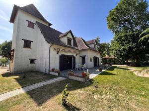 Saint-Hilaire-de-CourtにあるLe Poirier au Roi, Villa avec Piscine, Jacuzzi, Parc, Etang et calmeの広い庭のある大きな白い家
