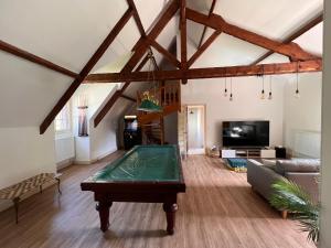 Saint-Hilaire-de-CourtにあるLe Poirier au Roi, Villa avec Piscine, Jacuzzi, Parc, Etang et calmeの卓球台のあるリビングルーム