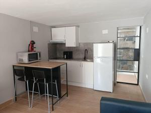 a kitchen with a refrigerator and a table with chairs at La Rueda, campo y playa en el Medano in El Médano