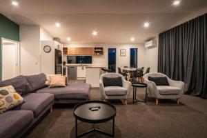 a living room with a couch and chairs and a table at Nova Heights in Lake Tekapo