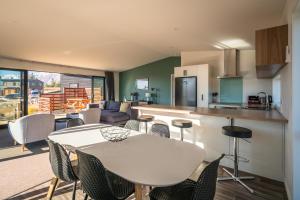 a kitchen and living room with a white table and chairs at Nova Heights in Lake Tekapo +10 photos