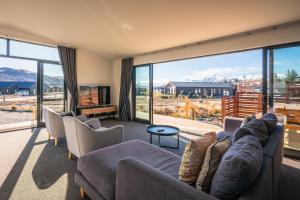 a living room with a couch and chairs and a large window at Nova Heights in Lake Tekapo