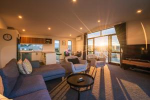 a living room with a couch and chairs and a piano at Nova Heights in Lake Tekapo