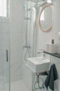 a white bathroom with a sink and a shower at CH Barco in Madrid