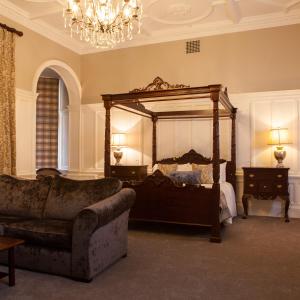 een slaapkamer met een groot bed en een bank bij Inglewood House and Spa in Alloa