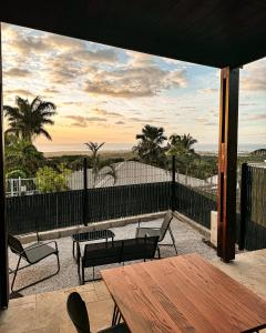Le Bois de NèflesにあるLe perchoir - tiny house avec vue merのテーブルと椅子があり、海の景色が見えるパティオ