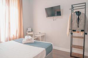 a bedroom with a bed with a suit on a rack at CH Barco in Madrid
