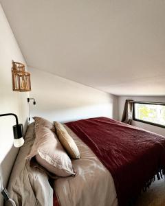 Le Bois de NèflesにあるLe perchoir - tiny house avec vue merのベッドルーム1室(枕付きのベッド1台、窓付)