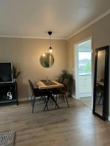 a dining room with a table and chairs and a mirror at Koselig leilighet på Østensjø med stor uteplass in Oslo