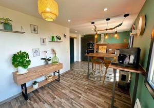 a kitchen and living room with wooden floors at Maison Campagne SPA, Sauna, cinéma, jardin in Valuéjols