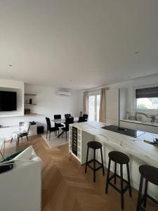 a living room with a kitchen with bar stools at Charmante maison à louer in Saint-Cyr-sur-Loire