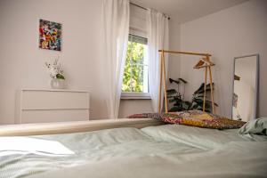 a bedroom with a bed with a mirror and a window at 70qm Pure Erholung in bester Lage in Idar-Oberstein