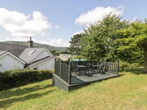 una terraza con mesa y sillas en un patio en Dale Cottage, en Llanrwst