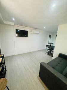 a living room with a couch and a white wall at Piso con jardín, de Playa Fenals in Lloret de Mar