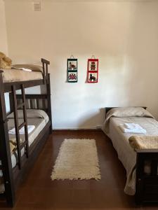 a bedroom with two bunk beds and a rug at Casa Ciao in Deán Funes