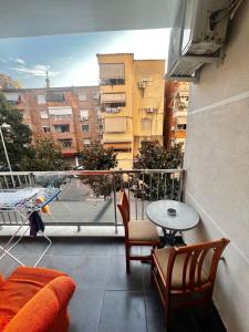 een balkon met een tafel en stoelen en uitzicht op een gebouw bij Cozy apartment in central tirane in Tirana