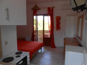 a small room with a bed and a kitchen at ANAMAMA -SOCRATES studios in Acharavi
