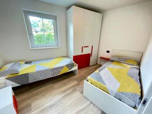 a bedroom with two beds and a window at Appartamento - Chalet Baltmann - Lavarone in Lavarone