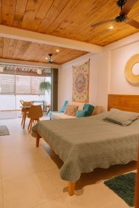 ein Schlafzimmer mit Bett und ein Wohnzimmer in der Unterkunft Apartamentos Orla Itacaré - Casa Flor in Itacaré